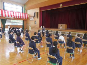 体育館に並べられたパイプ椅子に座る生徒たち1