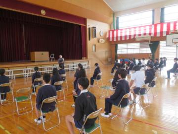 体育館に並べられたパイプ椅子に座る生徒たち2