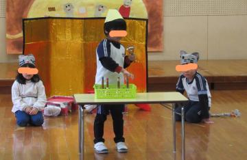 おじいさんの前で得意技のミュージックベル奏を披露している写真