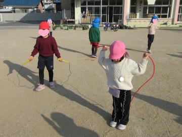 園庭で縄跳びをしている園児たちの様子