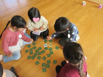 室内の床でメモリーカードで遊ぶ園児たちの様子