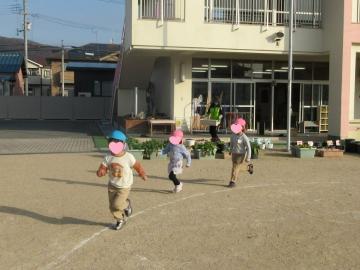 園庭でマラソンをしている園児たちの様子
