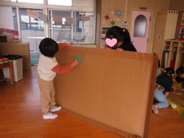 室内で段ボールを切っている園児たちの様子