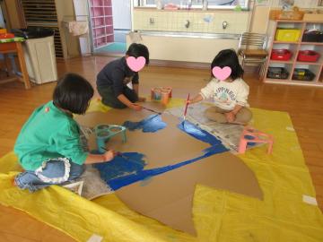 室内で魚の工作に色を塗っている園児たちの様子