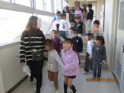 幼稚園児たちが小学校の廊下を歩いているようす