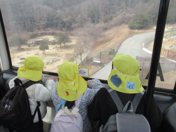 園内でゴンドラの窓から地上を見下ろしている園児たちの様子