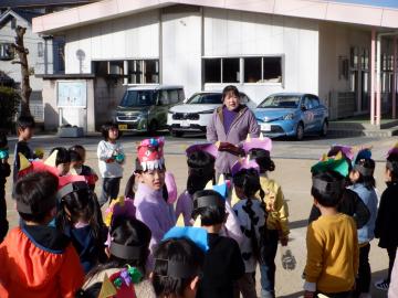 庭で立ったまま園長の話を聞く幼児