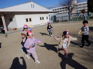 庭で豆まきをする幼児
