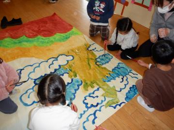 劇の背景を絵具で描いているようす