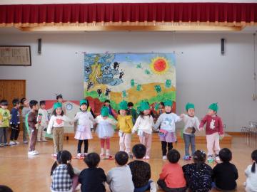 友達と手をつないで並んで歌を歌っているようす