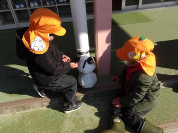 下駄箱の前で雪だるまをつくった幼児