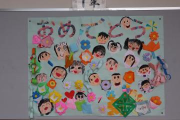 在校生から6年生へのおめでとうのイラストを掲示版に掲示している様子