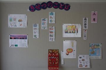 「3月の季節の言葉について」の掲示物が掲示板に貼られている様子