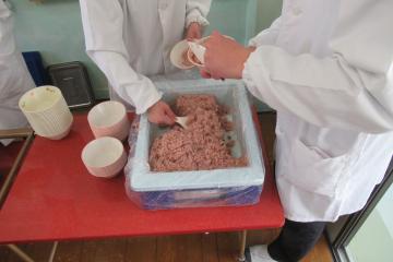 9年生給食当番が赤飯をよそう写真