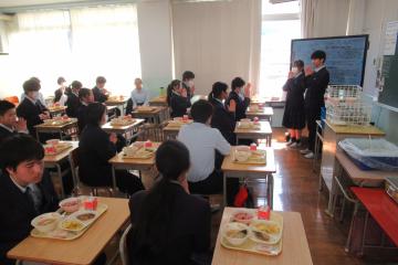 配膳された給食を前に、9年生が手をあわせていただきますをしている様子