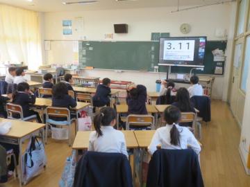 教室で東日本大震災についての話を聞く1年生の児童たちの様子