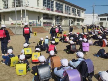 運動場での交通班旗の使い方を確認する新登校班長たちの様子