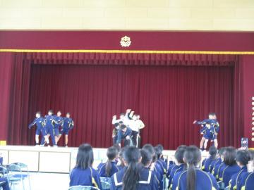 生徒と先生が体育館の壇上でオープニングダンスを踊る様子