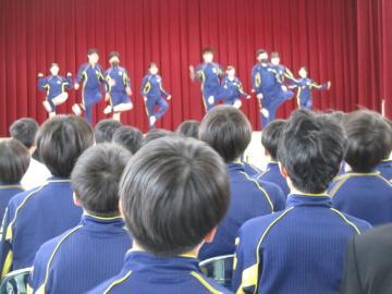 1組の位グループが体育館の壇上でダンスを踊る様子