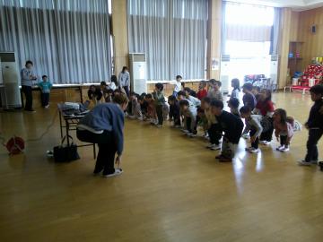 「Head, shoulders, knees and toes」の歌に合わせて、体や顔を順に触っている様子