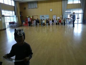 「What's the time, Mr.Wolf?」のゲーム　体育館でオオカミ役と逃げる役に分かれているこどもたち