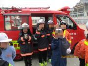 消防士さんの格好で記念撮影する児童たちの様子