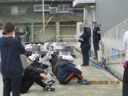 屋外で座り警官のお話を聞く児童たちの様子