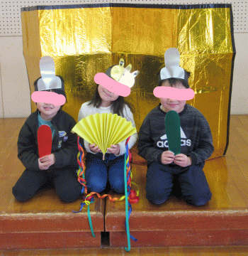 金屏風の前でお内裏様とお雛様になって記念撮影をしている子ども達