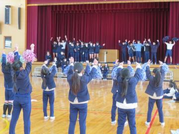 体育館で4年生によるダンスを見て一緒に踊る6年生の様子