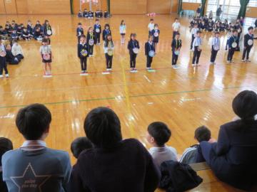 体育館で、メダルを首にかけ、「ありがとうの花」を歌う1年生の様子