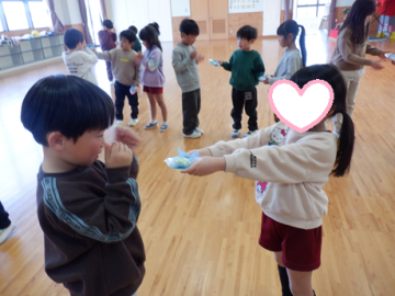 遊戯室でプレゼントを渡している園児たちの様子