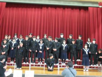 体育館のひな壇に生徒が並んでいる