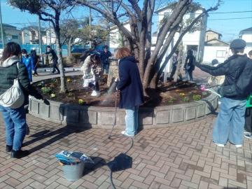 花壇に水をやる教師の様子