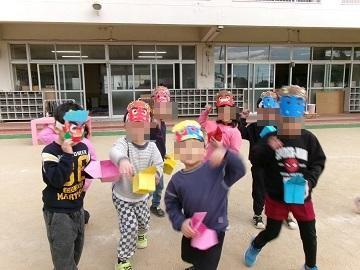 鬼のお面を付けて豆まきをしている子供たちの写真1