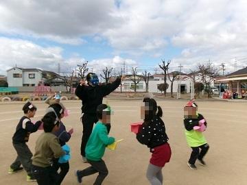 教師が鬼役をしてその周りを走るこどもたち写真