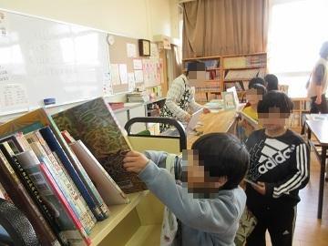小学校の図書室で本を返却している子供たちの写真