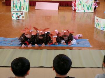 オオカミ役の子供が川に見立てたシートに寝転がっている写真