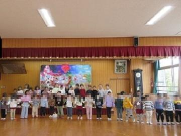 遊戯室で全園児が歌を歌っている写真