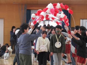 花のアーチを6年生が通っている写真