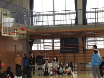 6年生とバスケットボールのシュート対決をしている写真