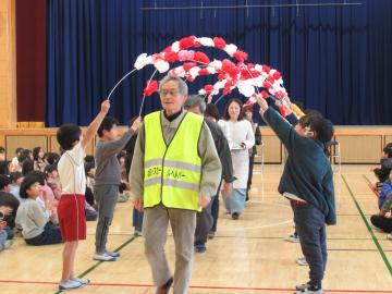 花のアーチでヘルパーさんたちをお送りしている写真