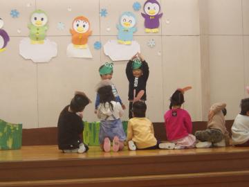 遊戯室の壇上で3歳児たちがお話遊びをしている様子