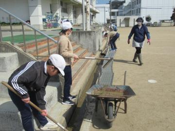 運動場の溝掃除をする6年生その3