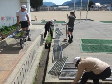 運動場の溝掃除をする6年生その1