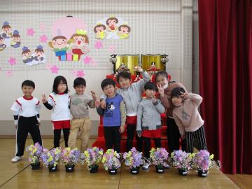 室内で園児たちがひな祭り会で集合写真を撮っている様子