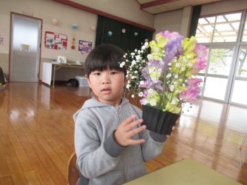 室内で園児がフラワーアレンジメントで花を生けた様子