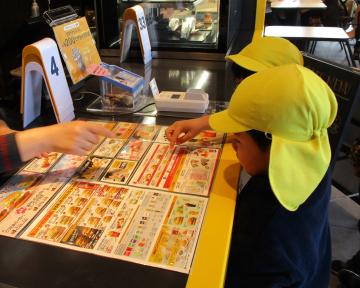 マクドナルドの店舗内のレジカウンターで園児たちがメニューを注文している様子