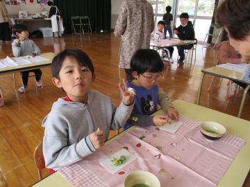 室内で園児たちがお茶会でお菓子を楽しんでいる様子
