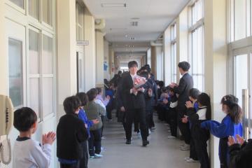 児童が校舎内の廊下の両サイドに並び拍手で9年生をお見送りをしている様子