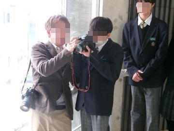 室内で講師と生徒1名が1つのカメラを一緒に覗いている様子